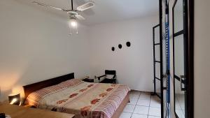 Recanto das tartarugas في مانغاراتيبا: غرفة نوم بسرير ومروحة سقف
