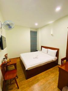 a small bedroom with a bed and a chair at Dũng India Hotel in Ho Chi Minh City