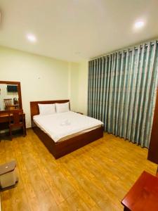 a bedroom with a bed and a desk in it at Dũng India Hotel in Ho Chi Minh City