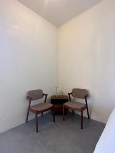 duas cadeiras e uma mesa num quarto em Mamori House at Kohlarn em Ko Larn