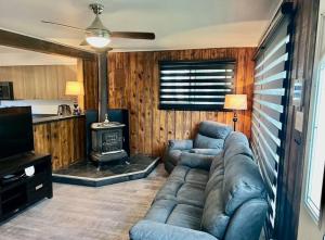 a living room with a couch and a stove at Chalet Plus Canada s.e.n.c. in Saint-Gabriel-de-Brandon