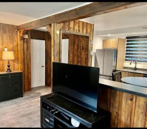 une cuisine avec une télévision à écran plat sur un comptoir dans l'établissement Chalet Plus Canada s.e.n.c., à Saint-Gabriel-de-Brandon