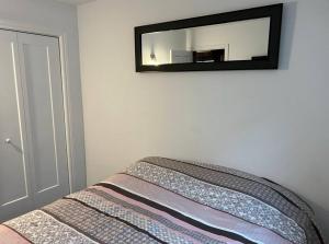 een slaapkamer met een spiegel aan de muur bij Chalet Plus Canada s.e.n.c. in Saint-Gabriel-de-Brandon