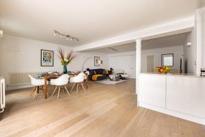 cocina y sala de estar con mesa y sillas en Wild Roses Serviced Apartments - Borough, en Londres