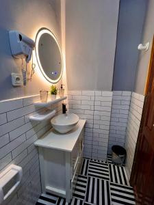 ein weißes Badezimmer mit einem Waschbecken und einem Spiegel in der Unterkunft Residence Ethan Nji - Tropical Paradise in Jaunde