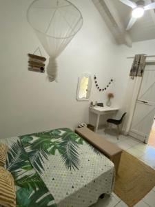 een slaapkamer met een bed, een tafel en een bureau bij Le Biabiany in Bouillante