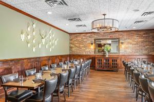 a dining room with tables and chairs and a brick wall at DoubleTree by Hilton Roseville Minneapolis in Roseville