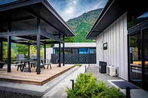 eine Außenterrasse mit einem Picknicktisch und Bänken in der Unterkunft UMEGASHIMA　DRIVEｰIN　＆　SAUNA　VILLA in Shizuoka