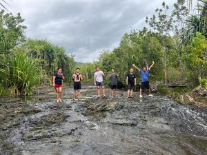 een groep mensen die op een rots in een rivier staan bij Daya Farm and Adventure 