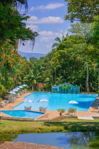 ein großer Pool mit Stühlen und Sonnenschirmen in der Unterkunft Hotel Estância Santa Isabel in Santa Isabel
