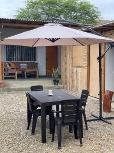 a black table and chairs under an umbrella at Vista Palmeras in Zorritos