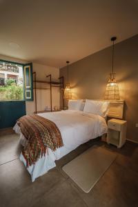 a bedroom with a large white bed and two lights at Cocli Hotel Boutique Salento in Salento