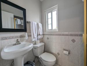bagno con lavandino, servizi igienici e specchio di Ocean Park Inn a Los Angeles