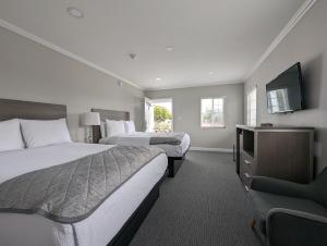 een hotelkamer met 2 bedden en een flatscreen-tv bij Ocean Park Inn in Los Angeles