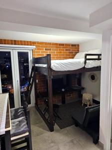 a room with two bunk beds in a brick wall at Nuevo y Moderno apartamento en la atractiva Zona 4 in Guatemala