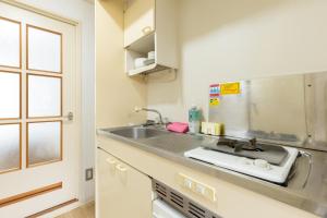 a kitchen with a sink and a counter top at Inoguchi View Heights in Itsukaichi