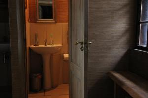 a bathroom with a sink and a toilet and a door at Chill Inn in Bernāti +33 photos
