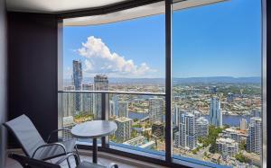 a room with a table and chairs and a large window at Beachside Ocean view 1-bedroom apartment in Ocean Building in Gold Coast