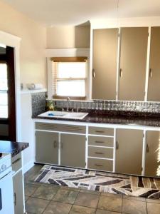 uma cozinha com armários brancos e um lavatório em The House Hotels- Thoreau Upper - Lakewood - 10 Minutes to Downtown Attractions em Lakewood