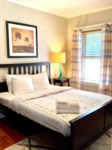um quarto com uma cama com almofadas e uma janela em The House Hotels- Thoreau Upper - Lakewood - 10 Minutes to Downtown Attractions em Lakewood
