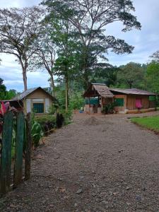 eine Gruppe kleiner Häuser mit Bäumen im Hintergrund in der Unterkunft Cabinas casa Jungla in Drake