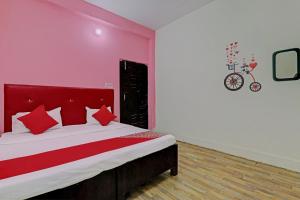 - une chambre avec un grand lit et une tête de lit rouge dans l'établissement OYO Flagship Relax Stay In, à Lucknow