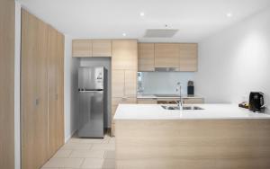 a kitchen with a refrigerator and a counter top at Convenient Located 2 Bedroom Apartment Next to Casino in Gold Coast
