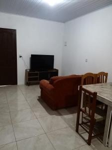 uma sala de estar com um sofá e uma mesa em Casas no Balneário Pérola / Arroio do Sal em Arroio do Sal