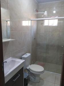 uma casa de banho com um WC, um lavatório e um chuveiro em Casas no Balneário Pérola / Arroio do Sal em Arroio do Sal