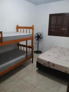 1 dormitorio con 2 literas y ventilador en Casas no Balneário Pérola / Arroio do Sal en Arroio do Sal