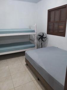 um quarto com 2 beliches e uma cadeira em Casas no Balneário Pérola / Arroio do Sal em Arroio do Sal