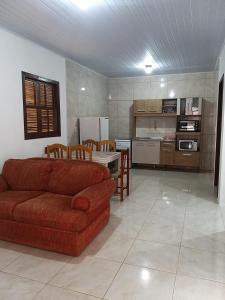 uma sala de estar com um sofá e uma cozinha em Casas no Balneário Pérola / Arroio do Sal em Arroio do Sal