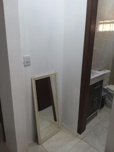 um espelho na casa de banho com um lavatório e um WC em Casas no Balneário Pérola / Arroio do Sal em Arroio do Sal