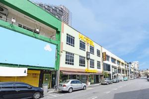 una strada con auto parcheggiate di fronte agli edifici di Mawardah Hotel Melaka Raya a Malacca