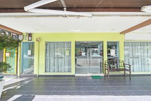 a building with glass doors with a bench in front at Seri Mawardah Hotel in Malacca +8 photos