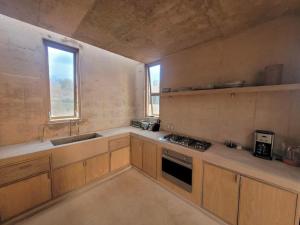 a kitchen with wooden cabinets and a sink and a window at Casa Naya in Puerto Escondido