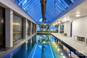 an indoor swimming pool with a large glass ceiling at VAQUAY Panorama In Southbank in Melbourne