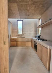 a large kitchen with wooden cabinets and a window at Casa Naya in Puerto Escondido