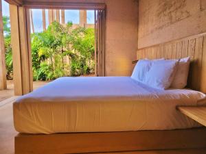 a bedroom with a large bed with a large window at Casa Naya in Puerto Escondido