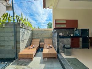 un patio avec trois chaises et une table ainsi qu'une cuisine dans l'établissement Villa magica 2, à Ubud
