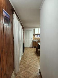 un pasillo que conduce a una cocina con mesa en casa a una cuadra del centrode ushuaia en Ushuaia
