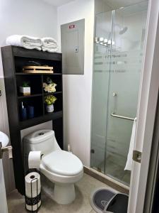 a bathroom with a toilet and a glass shower at Nuevo y Moderno apartamento en la atractiva Zona 4 in Guatemala