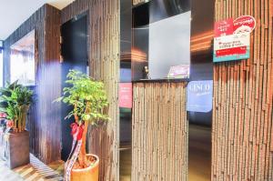 Yangsan的住宿－Ignis hotel，大堂设有竹墙和盆栽植物
