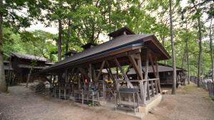un pabellón con techo negro en el bosque en Tabino Camping Base Akiu Tree House - Vacation STAY 23968v, en Yumoto