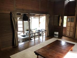 un soggiorno con pavimento in legno e tavolo di Tabino Camping Base Akiu Tree House - Vacation STAY 23970v a Yumoto