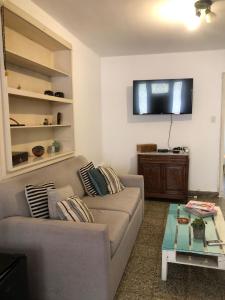 salon z kanapą i telewizorem z płaskim ekranem w obiekcie AlquilertemporarioGP w mieście General Pico