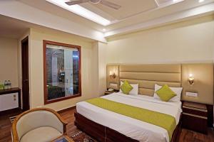 um quarto com uma cama grande e uma janela em Diamond Admire Hotel & Banquets by MMD em Noida