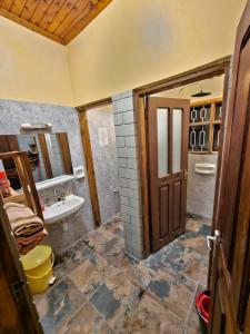 a bathroom with a sink and a toilet and a door at Mazzola Safari House & Backpacking in Arusha