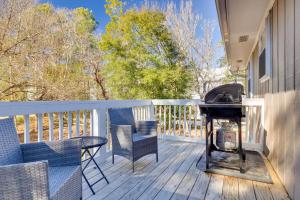 a grill on a deck with a table and chairs at Lovely Emerald Isle Home, Walk to Beach! in Emerald Isle