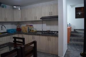 a kitchen with wooden cabinets and a table and a staircase at Casa privada en Tonsupa con piscina in Tonsupa